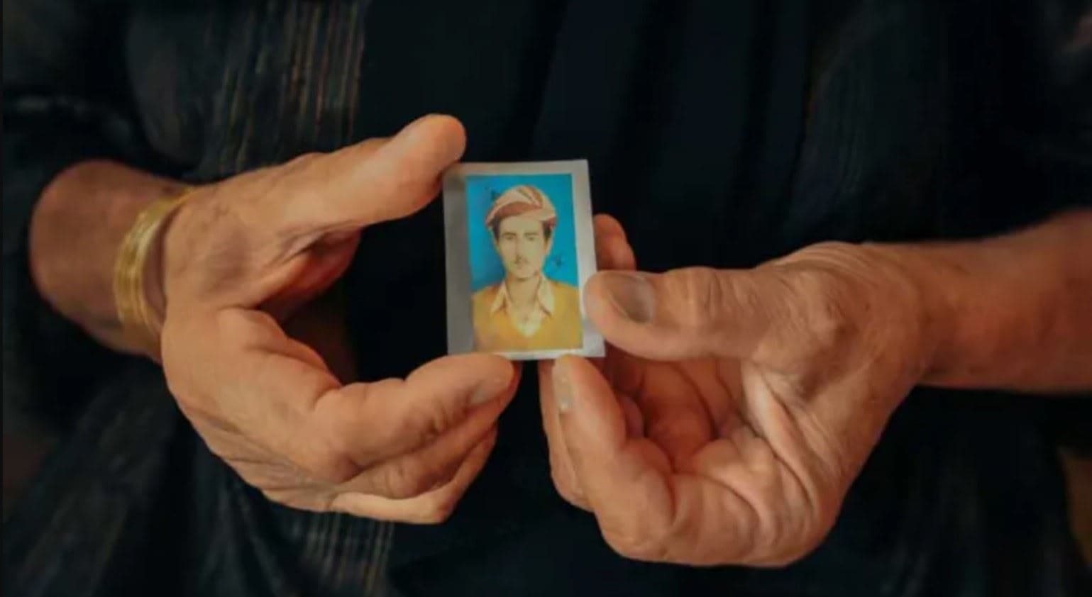 A woman holds the photo of a missing person. Photo: ICRC/file 