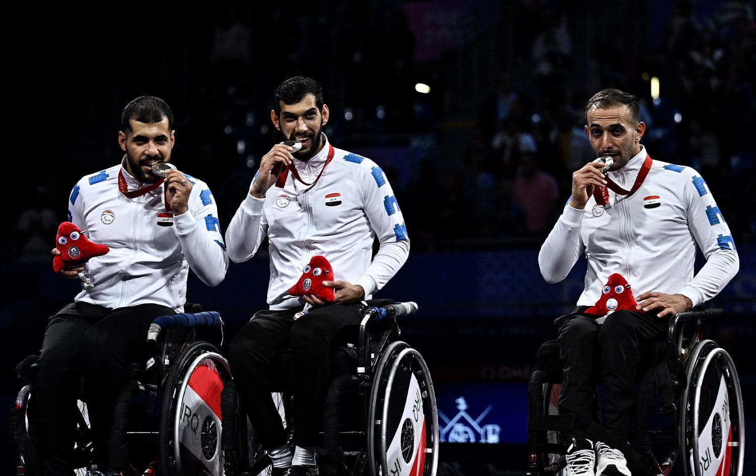 Iraq’s silver medalists Haider Ali, Zain Al-Abideen Gilan, and Ali Ammar pose on the podium of the wheelchair fencing men’s epee team event during the Paris 2024 Paralympic Games at the Grand Palais in Paris on September 7, 2024. Photo: Julien De Rosa/AFP