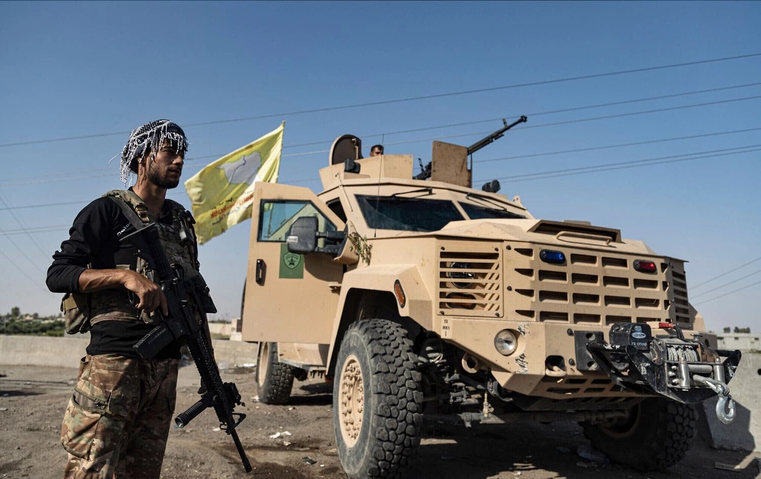 An SDF fighter stands next to an armored vehicle in eastern Syria’s Deir ez-Zor province on September 4, 2023. Photo: Baderkhan Ahmad/AP