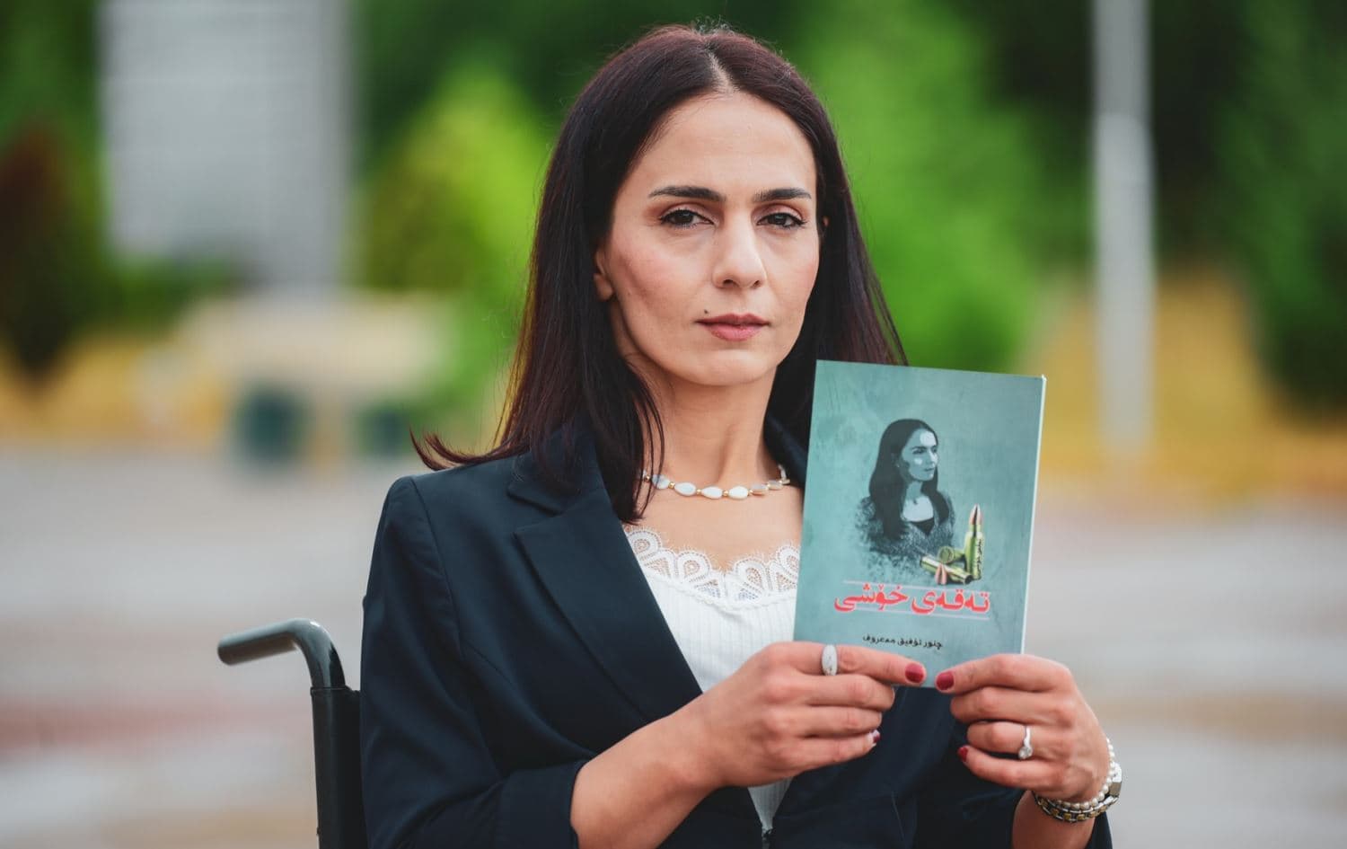 چنوور تۆفێق کتێبەکەی بەدەستەوە گرتووە