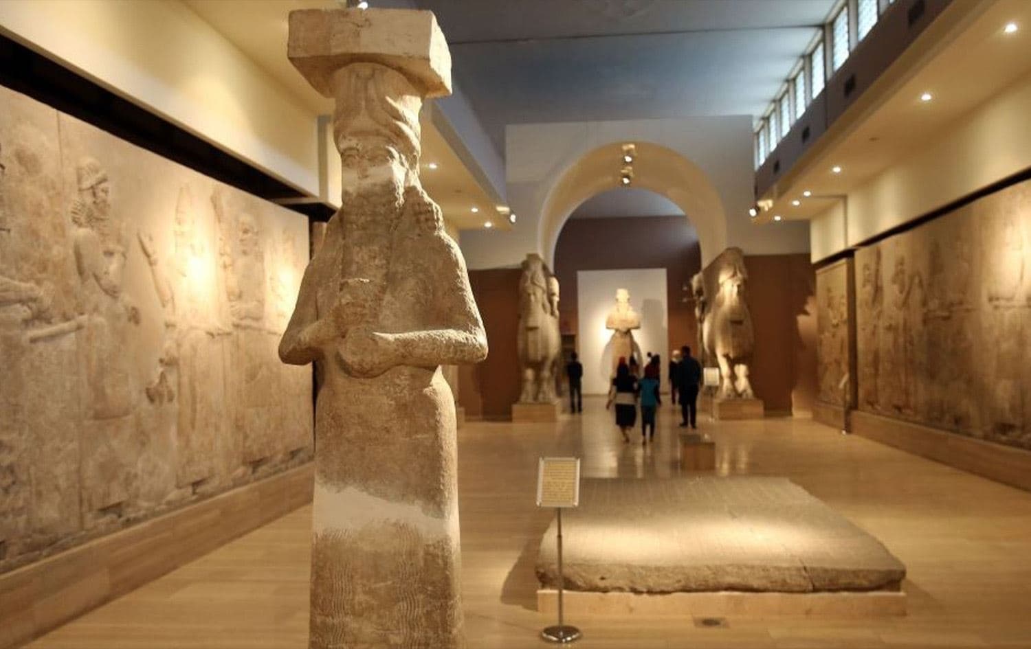People observe ancient artifacts at the Iraqi National Museum after its reopening in the wake of the destruction of Assyrian archaeological sites by the Islamic State (ISIS) in Mosul on March 15, 2015. Photo: Karim Kadhim/AFP