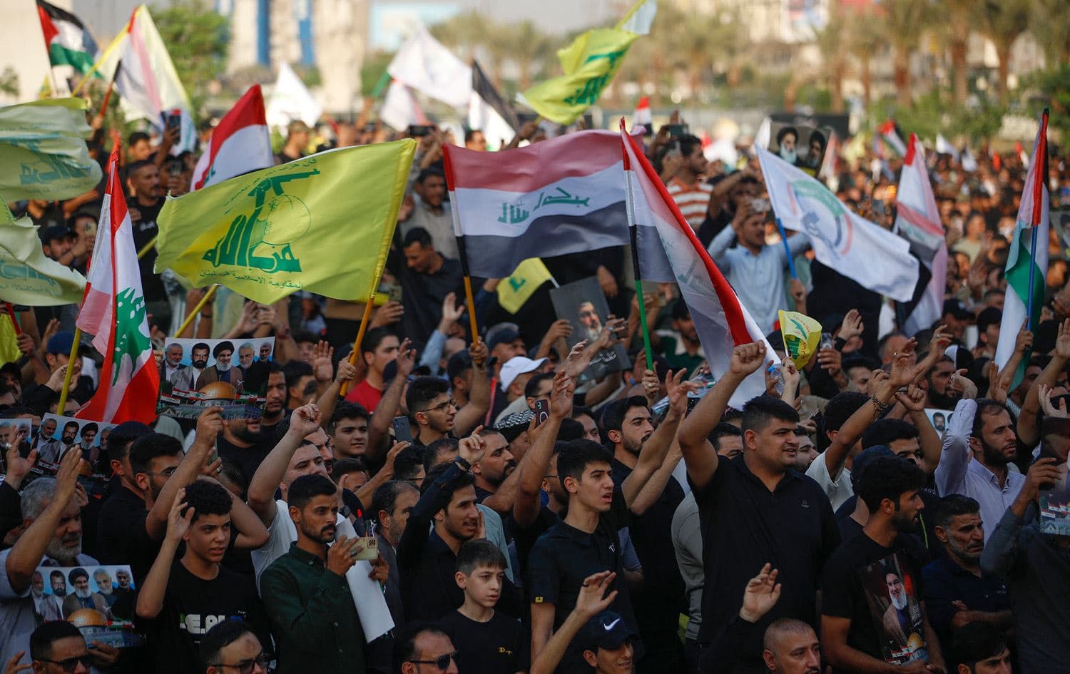 Iraqis raise pictures and flags in Tahrir Square in central Baghdad, during a protest against the ongoing Israeli bombardment of the Gaza Strip and Lebanon, on October 11, 2024. Photo: Ahmad al-Rubaye/AFP