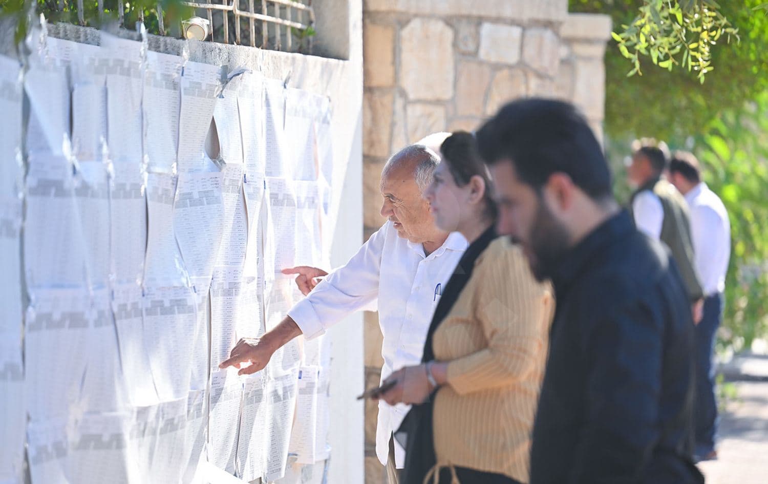 Residents in the Kurdistan Region scan papers attached to a polling station wall in search for their names during the regional parliamentary elections in Erbil on October 20, 2024. Photo: Bilind T. Abdullah/Rudaw