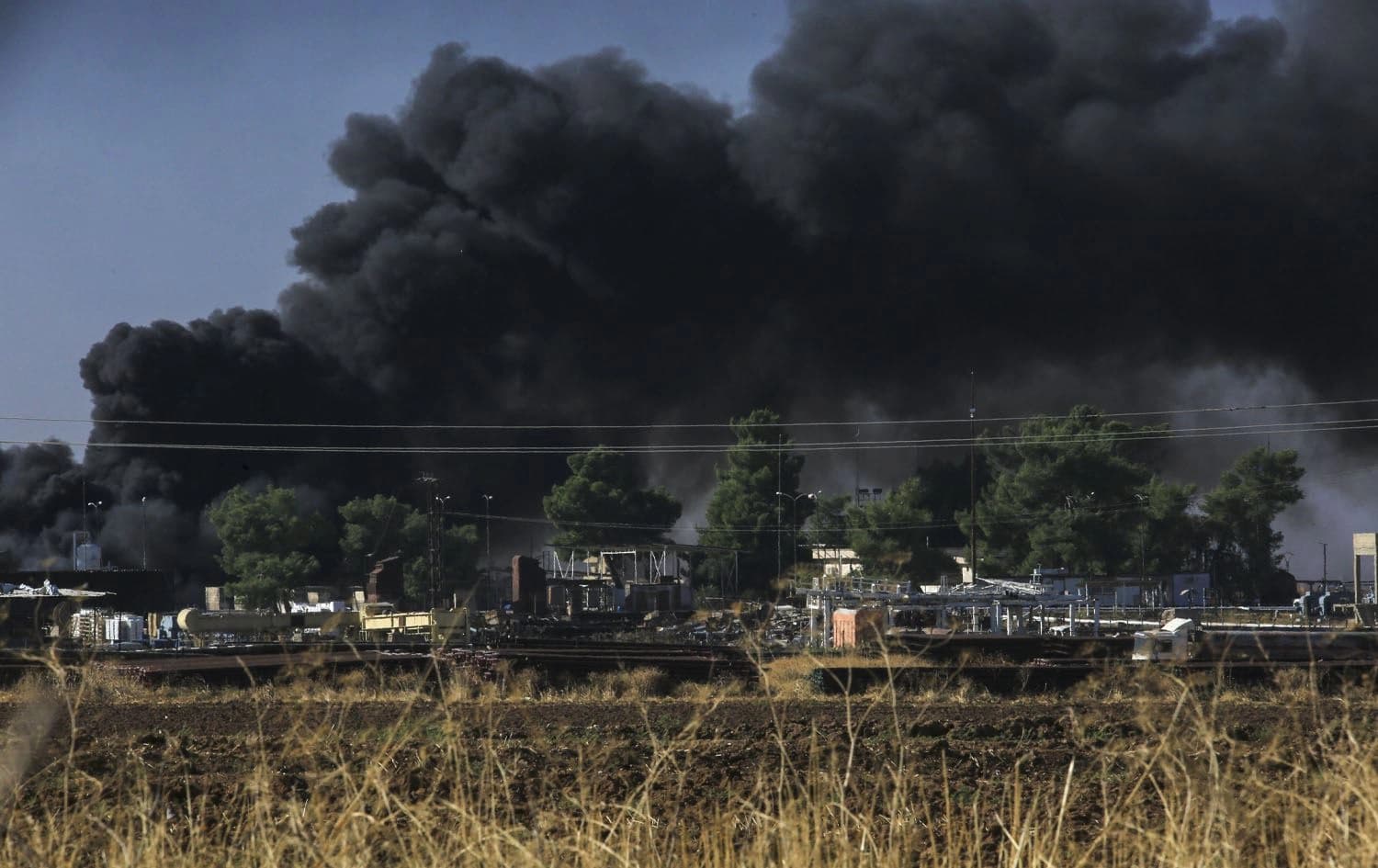 Thick smoke rises from an oil extracting facility targeted by Turkish shelling near Syria's northeastern border with Turkey in the Qahtaniyah countryside in the far northeast corner of Hasakeh province on October 25, 2024. Photo: Delil Soleiman/AFP