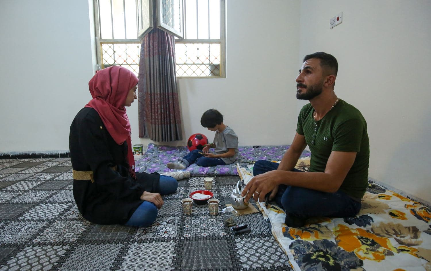 People have tea in a house sheltering families of Lebanese refugees after arriving in the central Iraqi city of Hilla on October 18, 2024. Photo: AFP/Karar Jabbar 