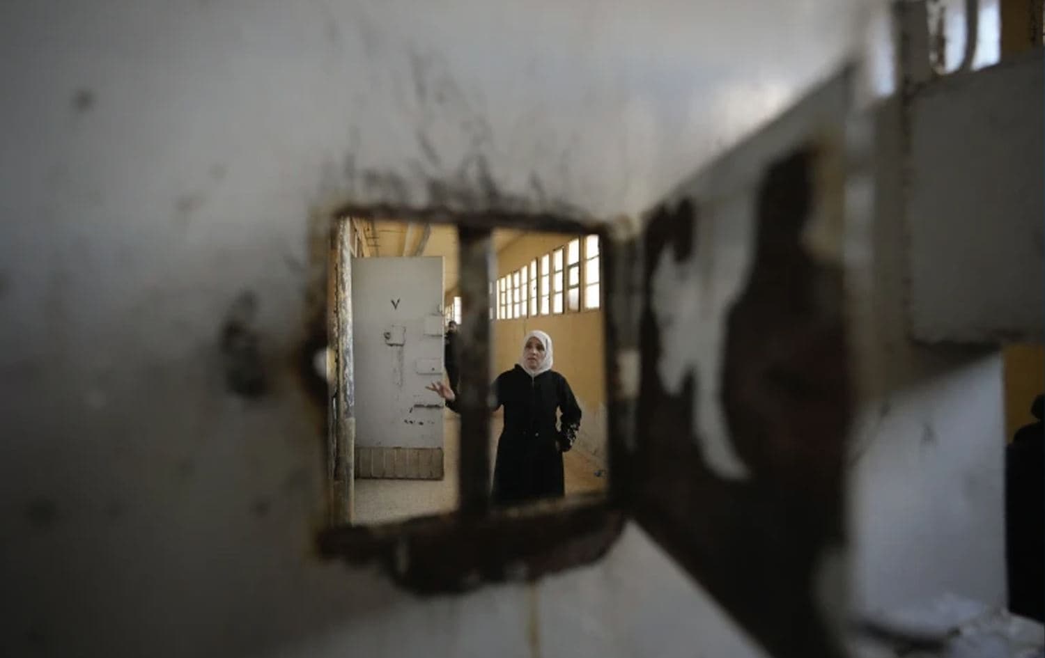 A woman examines a cell at the Saydnaya military prison in Damascus, Syria on December 9, 2024. Photo: AP/Hussein Malla