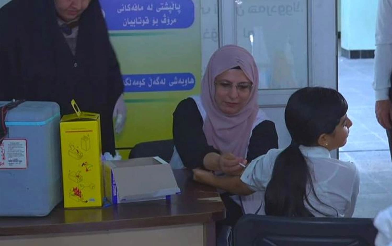 کارمەندێکی تەندروستی ڤاکسین لە منداڵێک دەدات. وێنە: رووداو