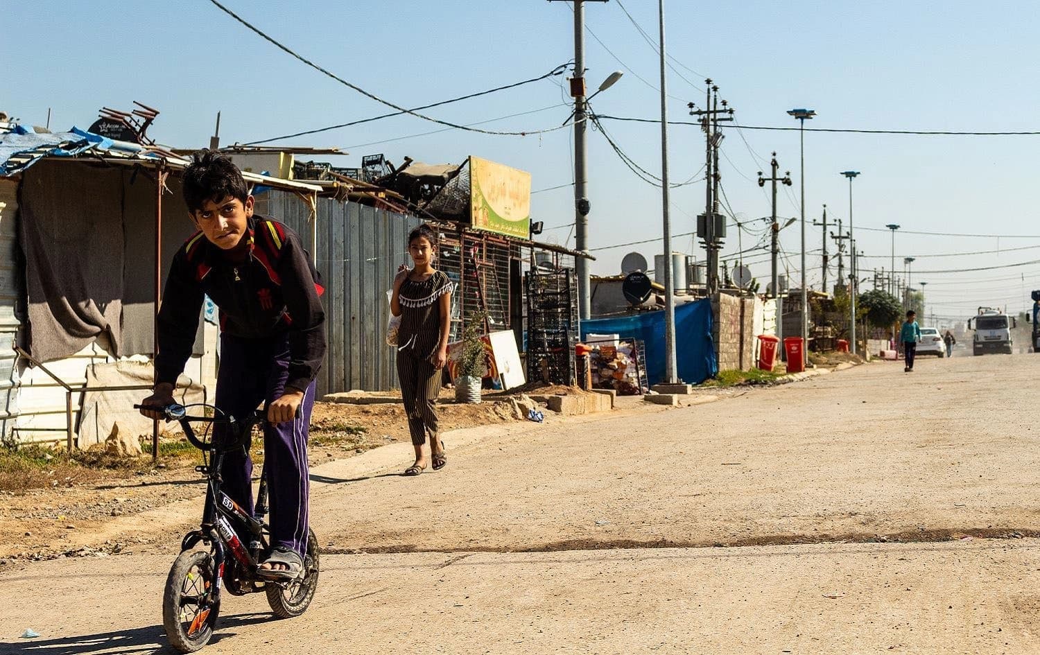 A Syrian boy rides a bike in Domiz refugee camp in the Kurdistan Region’s Duhok province, October 16, 2019. Photo: Hannah Lynch / Rudaw