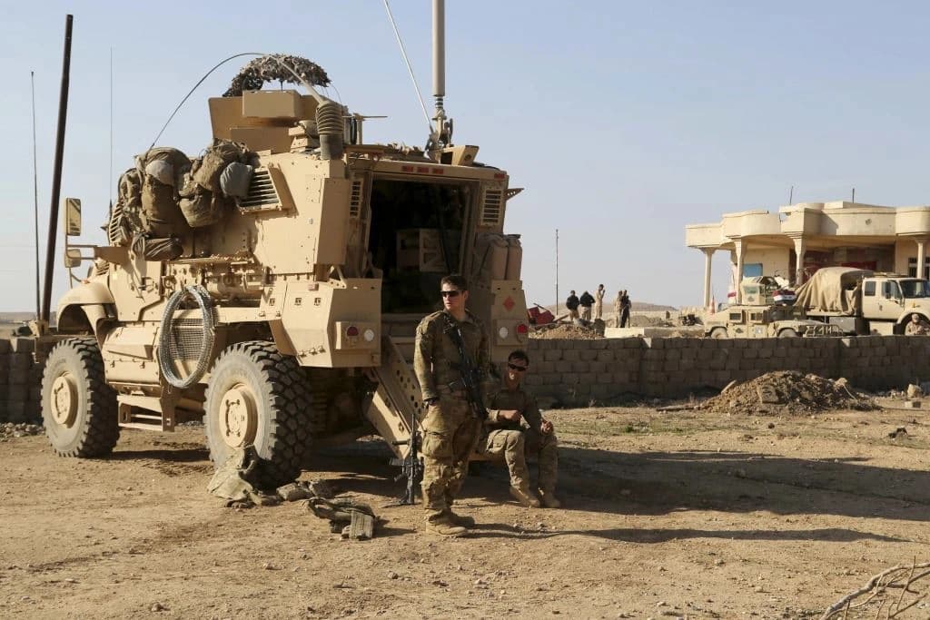 US Army soldiers stand outside their armored vehicle on a joint base with the Iraqi army, south of Mosul, Iraq on February 23, 2017. Photo: AP