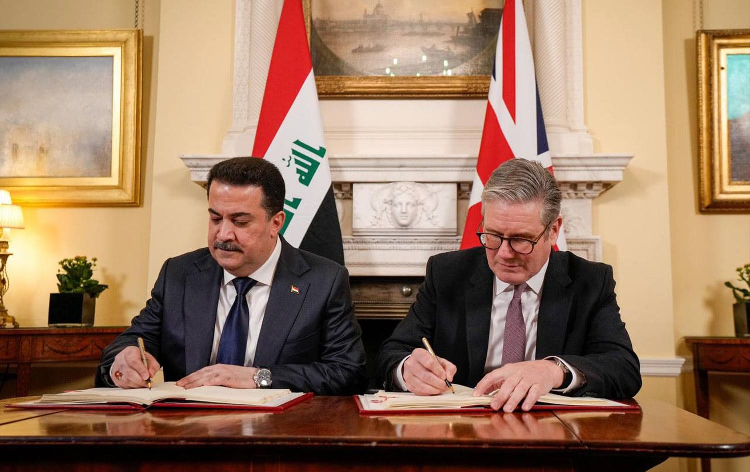 Iraqi Prime Minister Mohammed Shia' al-Sudani (left) and his British counterpart Keir Starmer (right) signing deals at 10 Downing Street in London on January 14, 2025. Photo: Sudani's office