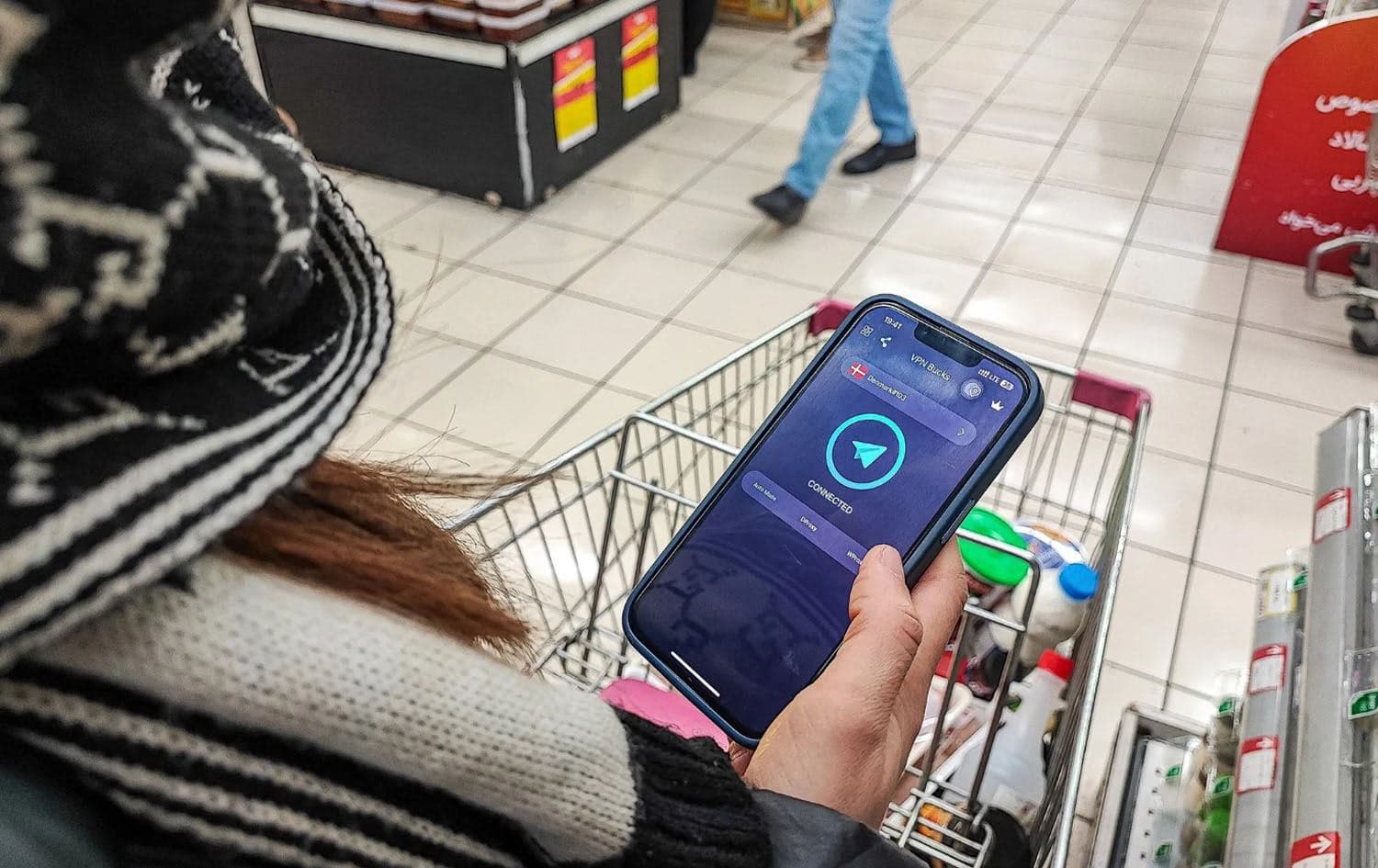 An Iranian holds a phone after activating a virtual private network (VPN) service to access internet while shopping in a supermarket in Tehran, Iran. Photo: AFP
