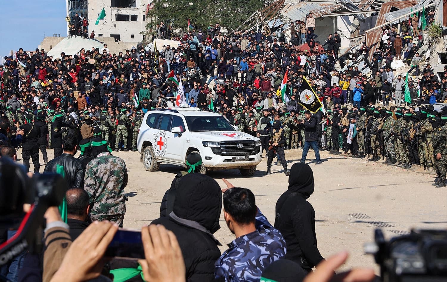 A Red Cross vehicle arrives in a square while Hamas fighters secure the area before releasing four Israeli hostages in Gaza City on January 25, 2025. Photo: Omar al-Qattaa/AFP