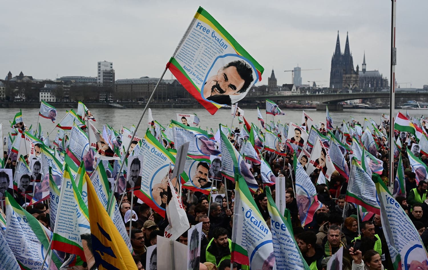 Supporters of the Kurdish community demonstrate with flags and banners on the occasion of the 25th anniversary of the arrest of Kurdistan Workers' Party (PKK) leader Abdullah Ocalan on the banks of the Rhine river in Cologne, western Germany, on February 17, 2024. Photo: AFP