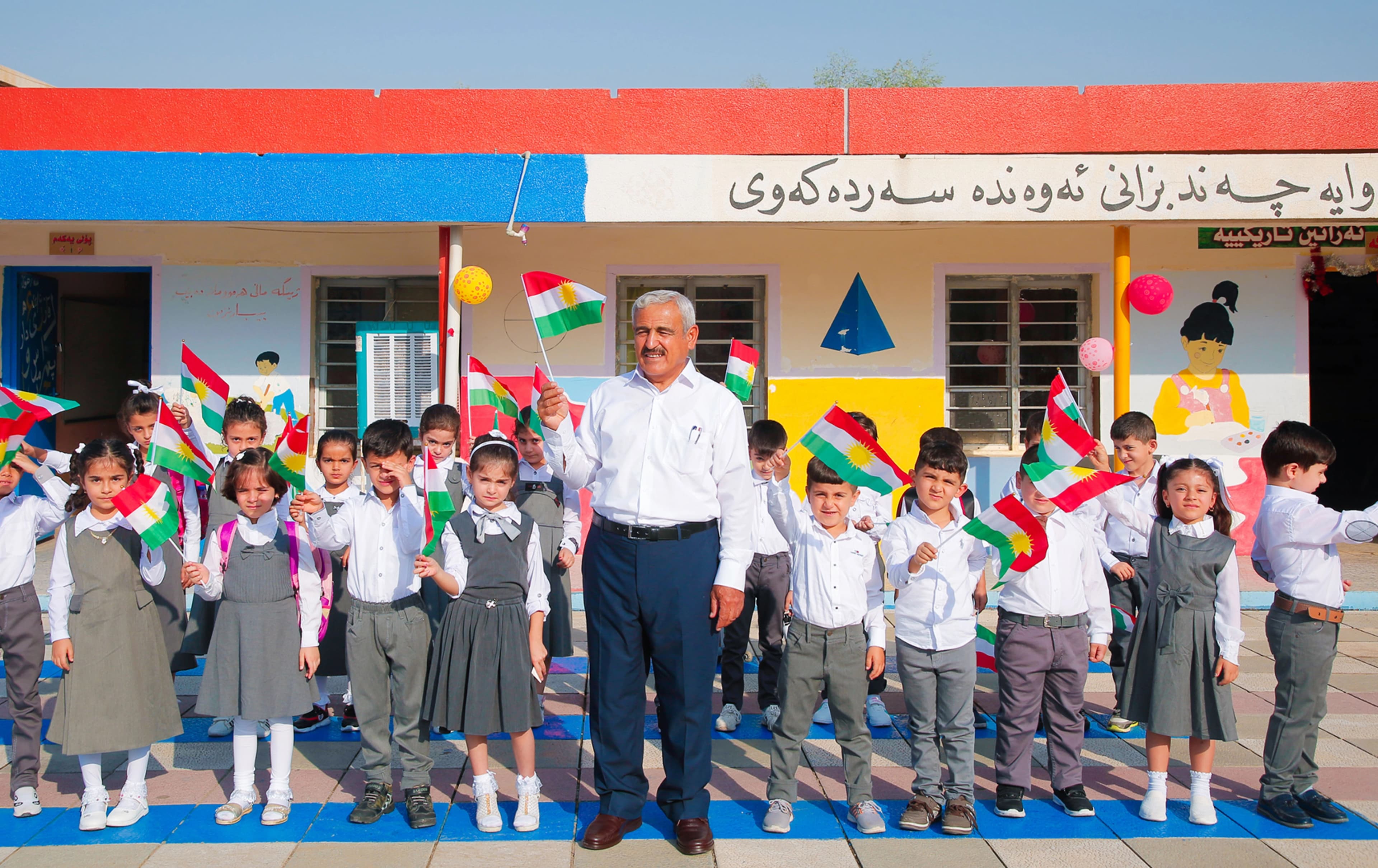مامۆستایەک لەنێو گۆڕەپانی قوتابخانەیەک لەگەڵ قوتابییەکانی. وێنە: بڵند تاهیر - رووداو
