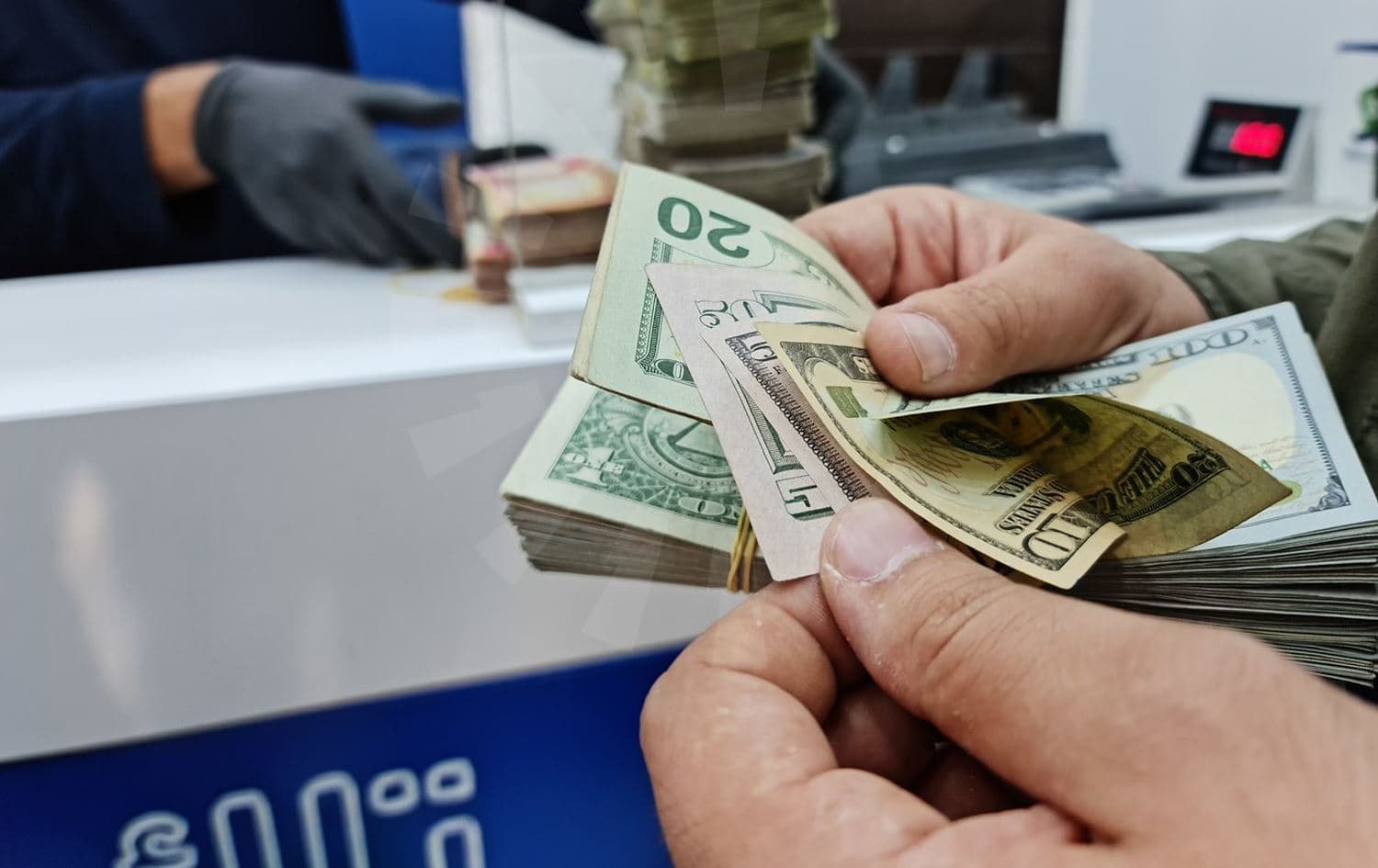  کەسێک دۆلاری ئەمریکی دەژمێرێت. وێنە بڵند تاهیر- رووداو
