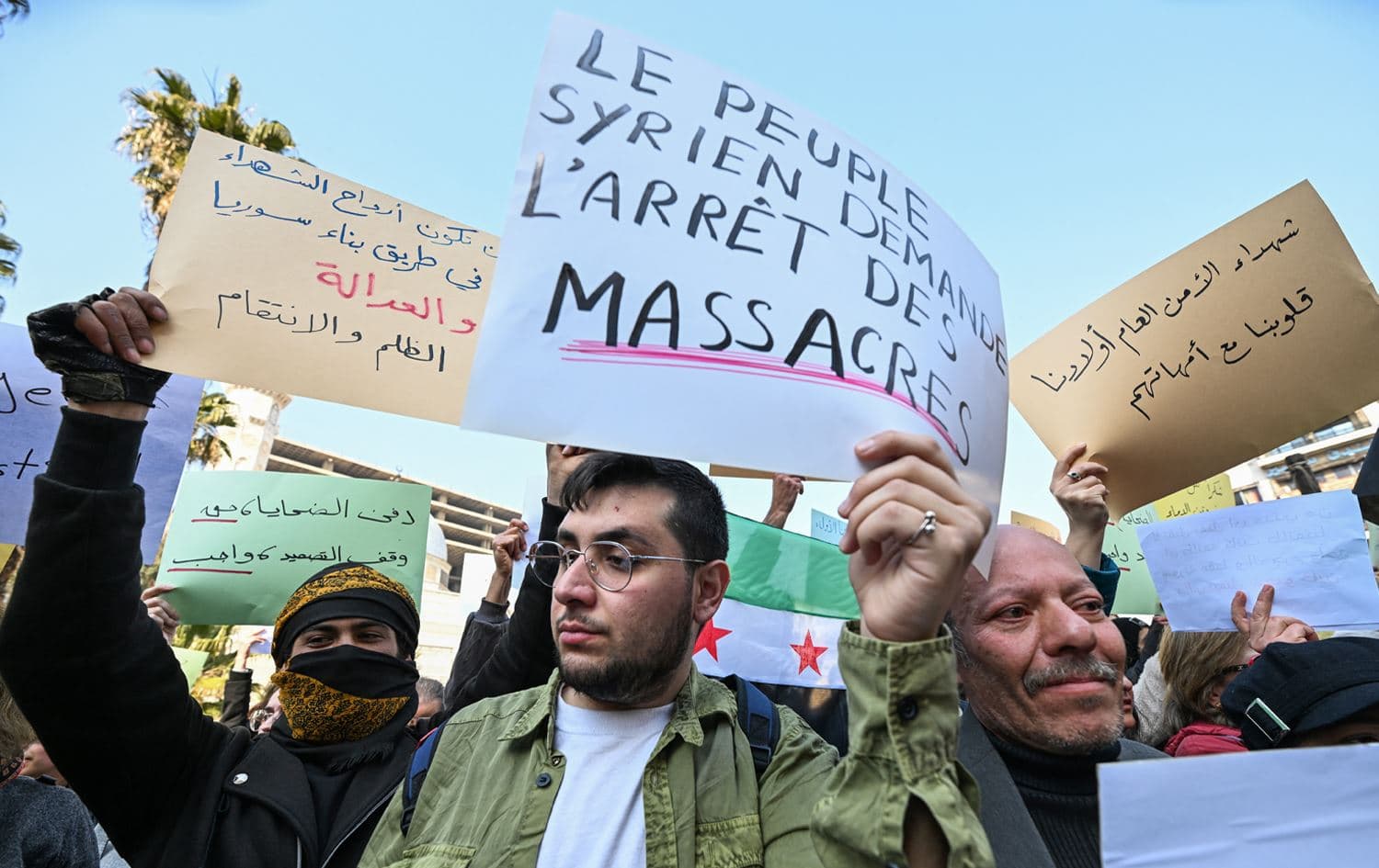 Demonstrators lift placards during a rally "to mourn for the civilian and security personnel casualties", at al-Marjeh square in Damascus on March 9, 2025. Photo: AFP