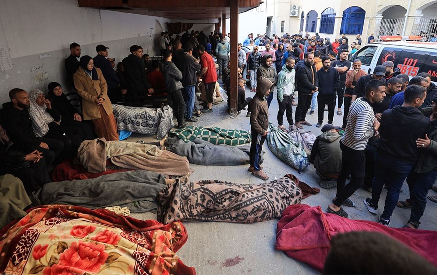 Palestinians stand next to slain kin at a hospital in the Gaza Strip on March 18, 2025. Photo: Rudaw