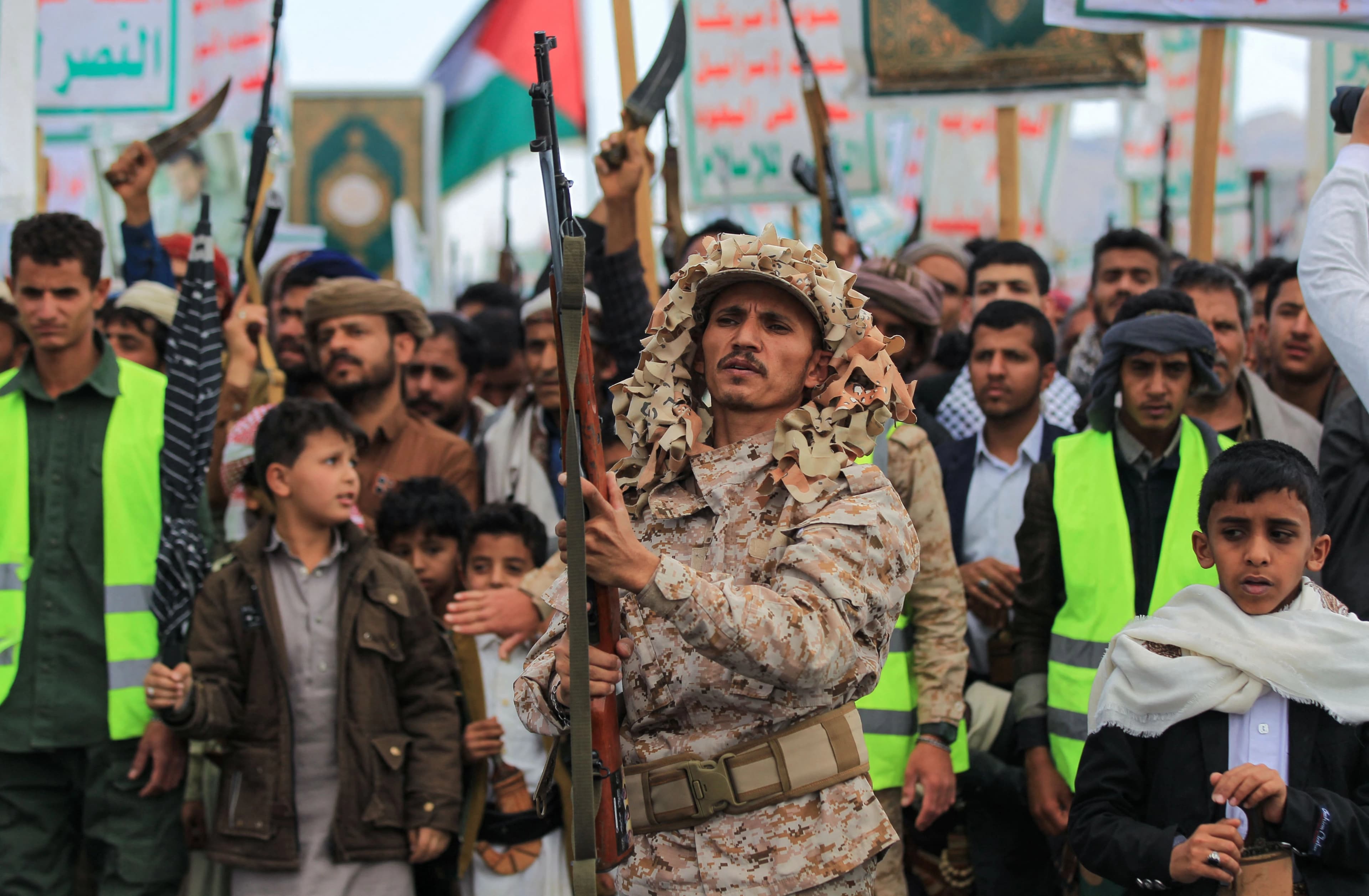 A member of Houthi-affiliated security forces brandishes a rifle as demonstrators chant during a protest called for by the rebel Houthi movement in Sanaa on March 17, 2025. Photo: AFP