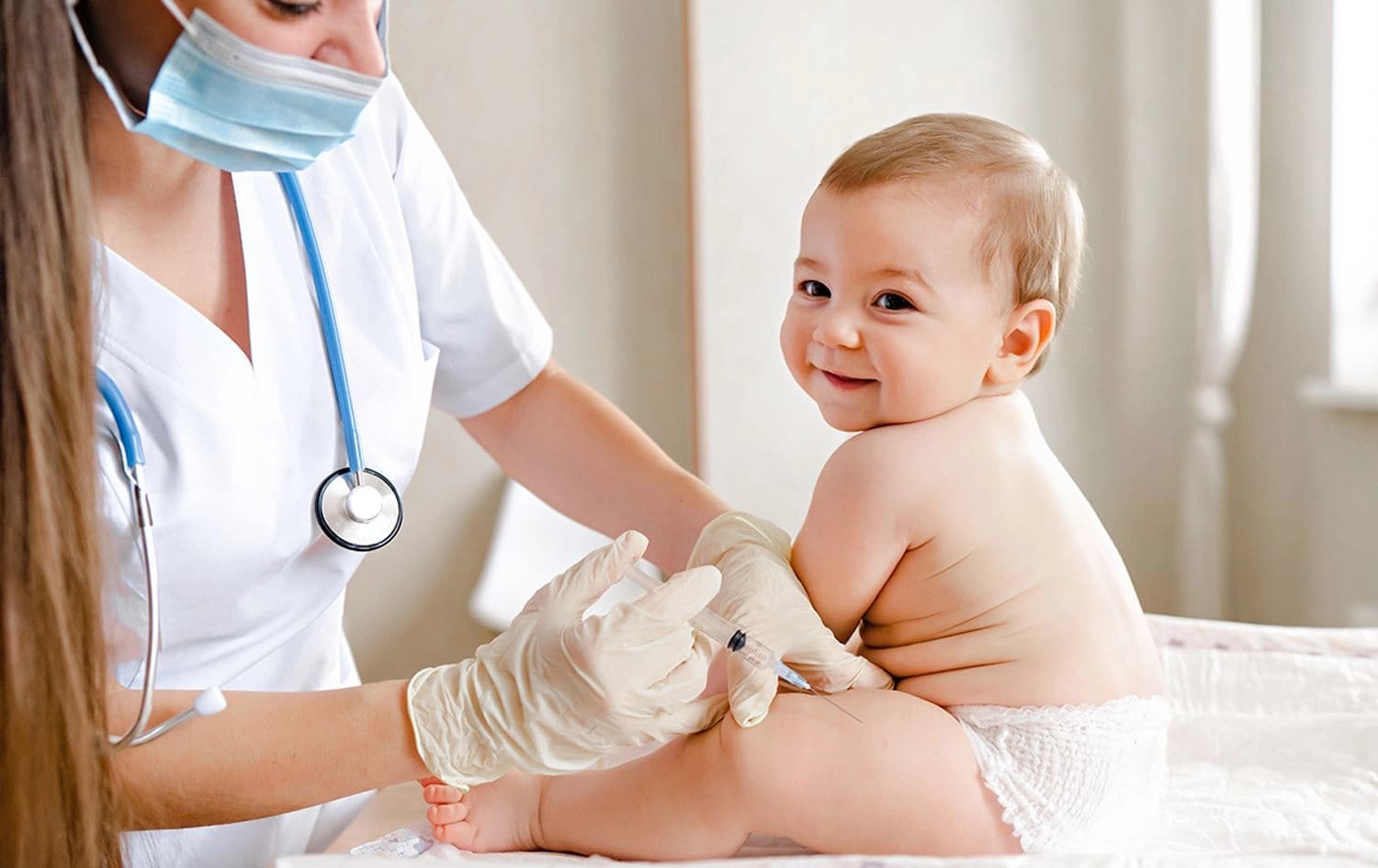 منداڵێک ڤاکسینی لێدەدرێت و لەو کاتەدا پێدەکەنێت. وێنە: Optum