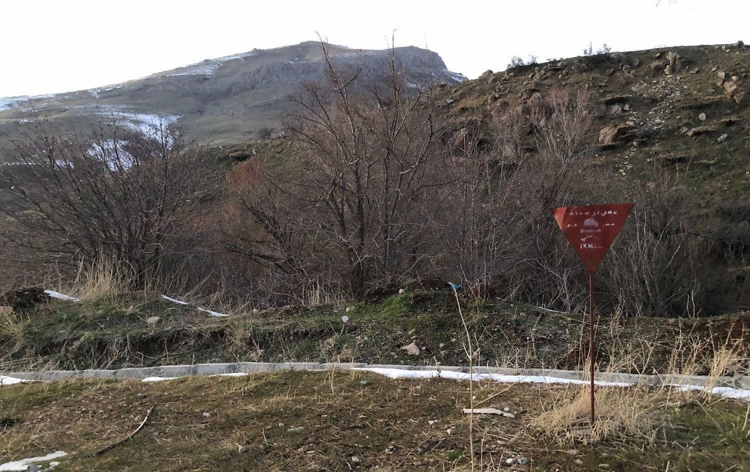 A sign marks a landmine on the side of a road in Halgurd-Sakran National Park near the Kurdistan Region's border with Iran in February 2021. Photo: Hannah Lynch/Rudaw
