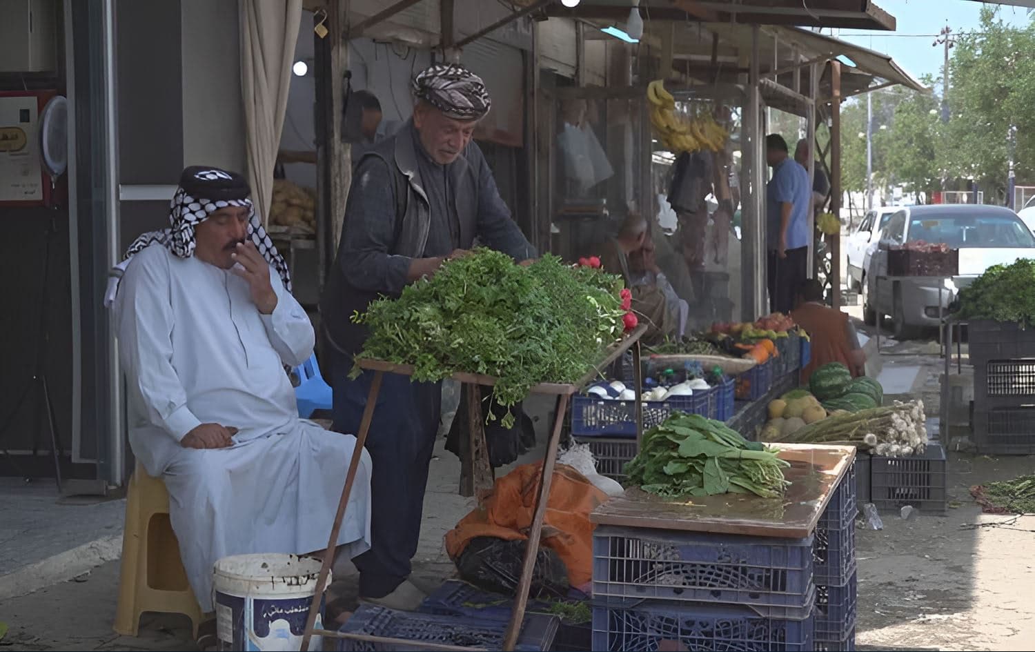 A man in traditional Iraqi Arab attire (left) and another in traditional Kurdish dress (right) pictured at a bazaar in Mandali, Diyala province, in April 2025. Photo: Rudaw
