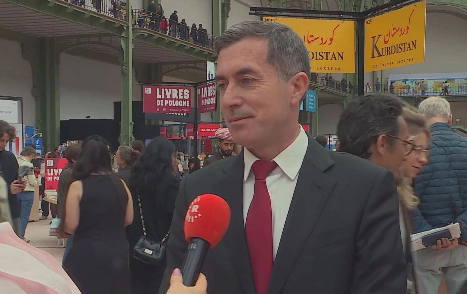 Ali Dolamari, the Kurdistan Regional Government’s (KRG) representative to France, speaking to Rudaw at the Paris Book Fair 2025 next to the Kurdistan book stand on April 13, 2025. Photo: Rudaw