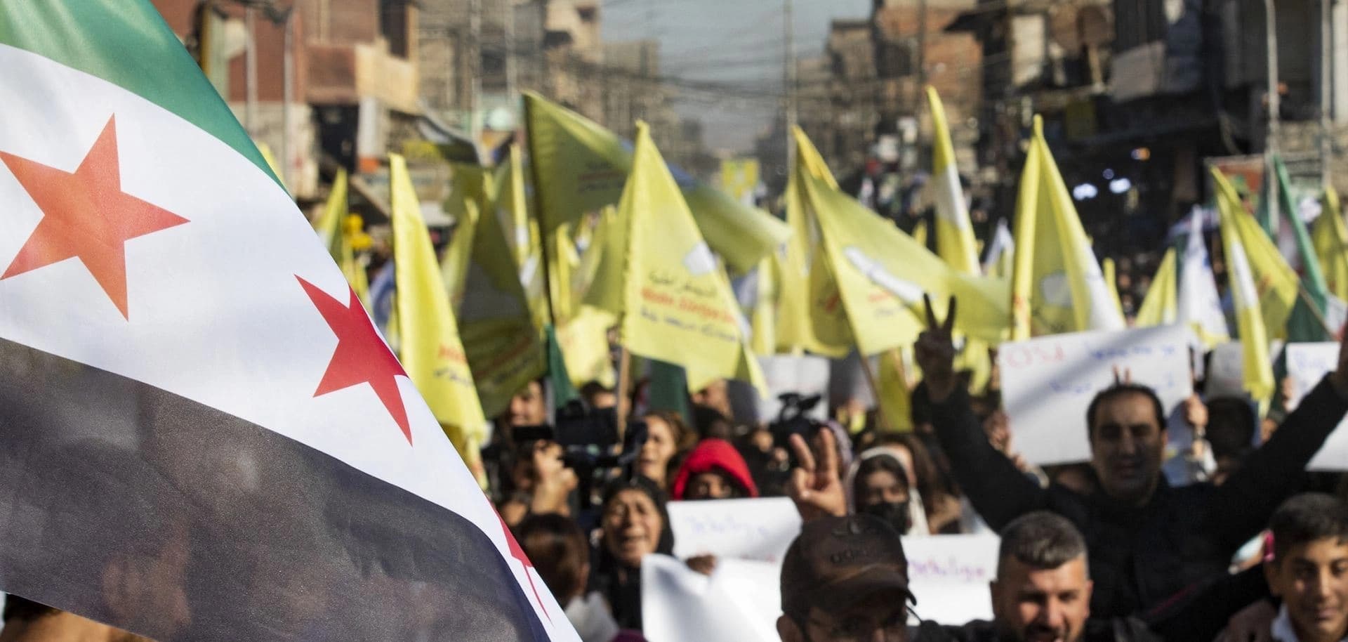 Syrian Kurds wave the flag of the SDF and the new Syrian flag in Qamishli on December 19, 2024. Photo: AFP