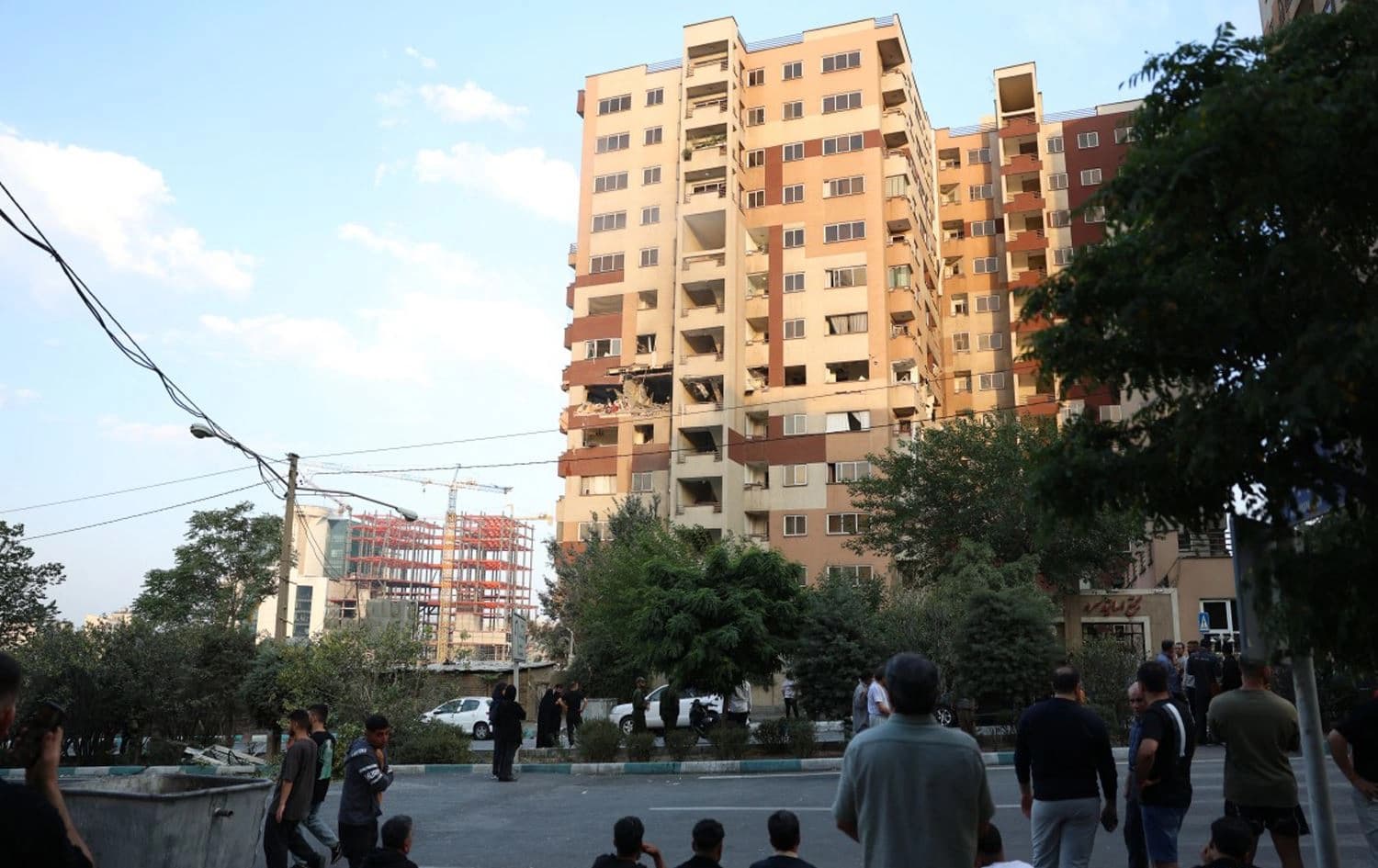 باڵەخانەیەکی ئێران بە ئامانج گیراوە و خەڵک بە دیاریەوە وەستاوە. وێنە: AFP
