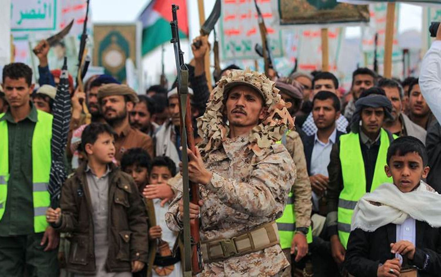 A member of Houthi-affiliated security forces brandishes a rifle as demonstrators chant during a protest called for by the rebel Houthi movement in Sanaa on March 17, 2025. Photo: AFP