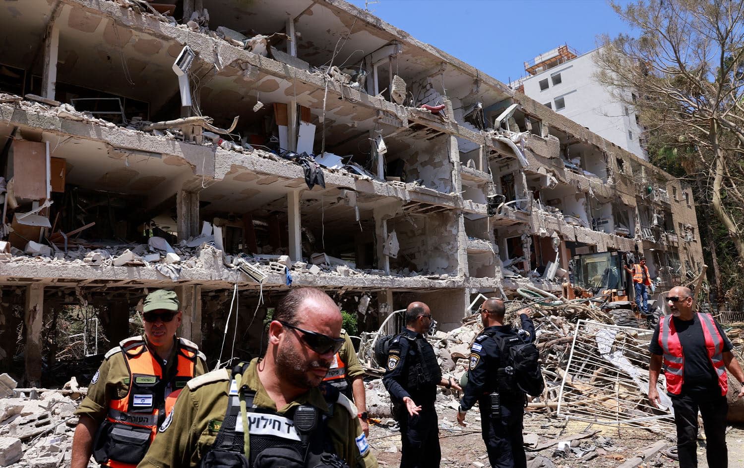 Israeli security forces and first responders gathering in front of a building damaged by an Iranian strike in Tel Aviv on June 22, 2025. Photo: Menahem Kahana/AFP