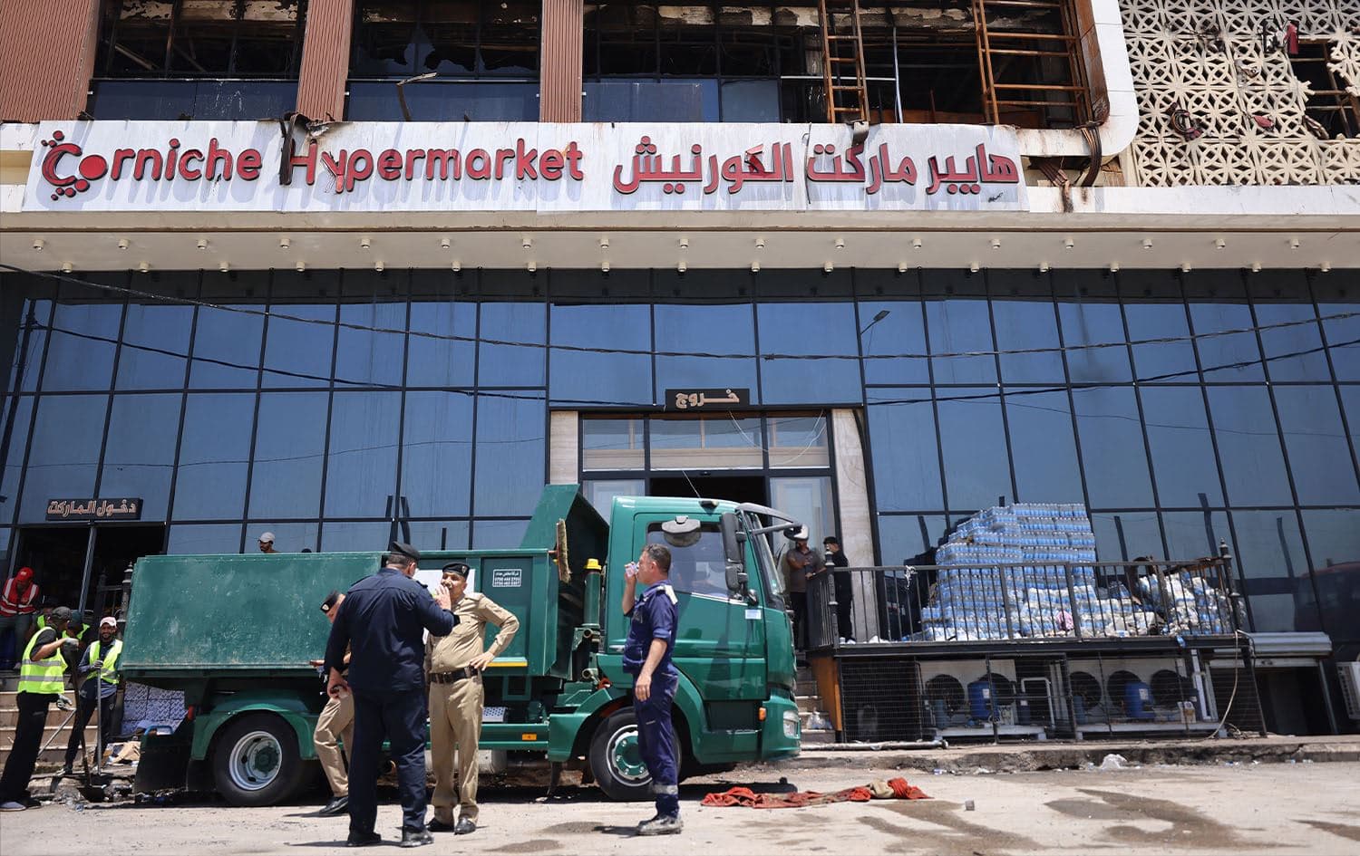 A cleaning operation starts outside the charred Hyper Mall building in the eastern Iraqi city of Kut on July 17, 2025. Photo: Ahmad al-Rubaye