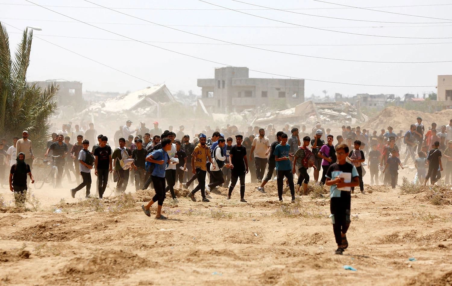 İsrail'in saldırısı ve ambargosu altındaki Gazze Şeridi'ne havadan paraşütle insani yardım malzemesi indiriyor. Filistinliler, yardım almak için birbirleriyle yarışıyor. / Foto: AA