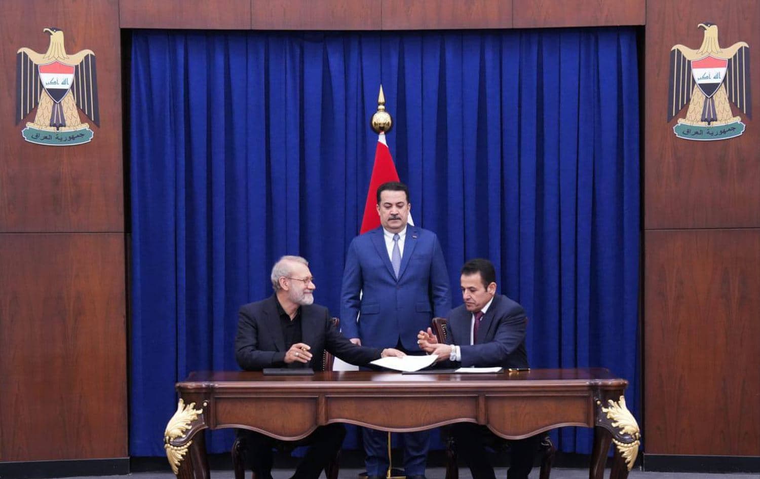 Iraqi National Security advisor Qasim al-Araji (left), Secretary of Iran's Supreme National Security Council Ali Larijani (left), sign an agreement overseen by Iraqi Prime Minister Mohammed Shia' al-Sudani (center), in Baghdad on August 11, 2025. Photo: Sudani's office