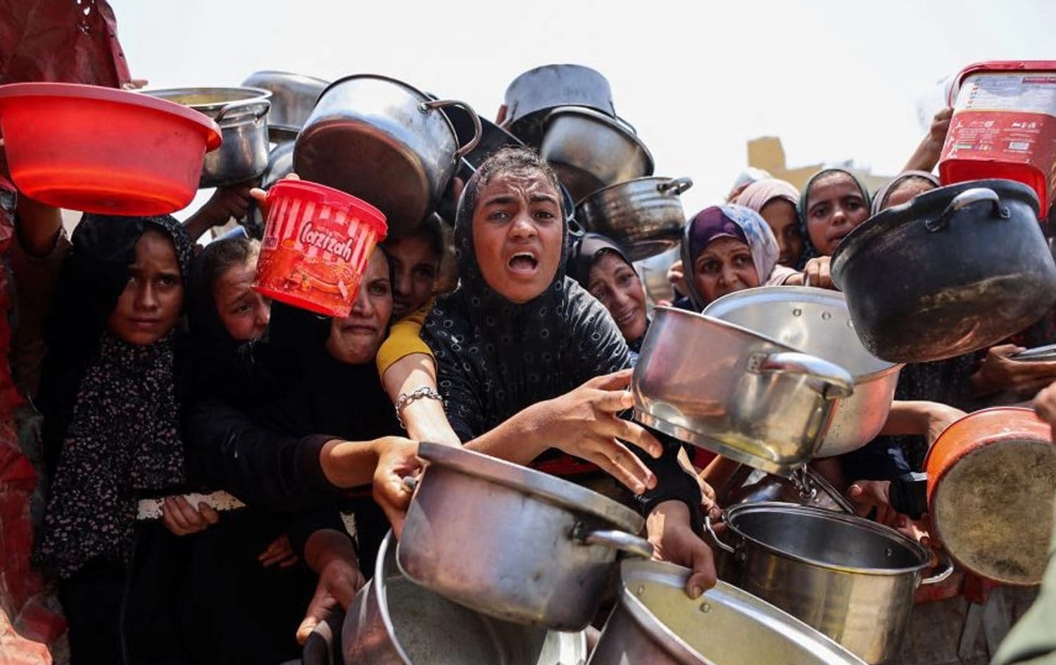 ژمارەیەک هاووڵاتیی غەززە چاوەڕێی ژەمێک خواردنن. وێنە: Omar Al-Qattaa/AFP