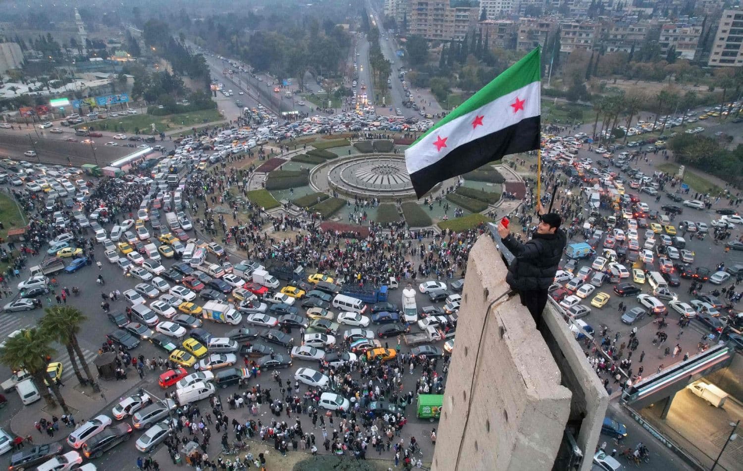  کەسێک بە ئاڵای سوویاوە لە گۆڕەپانی ئومەوی