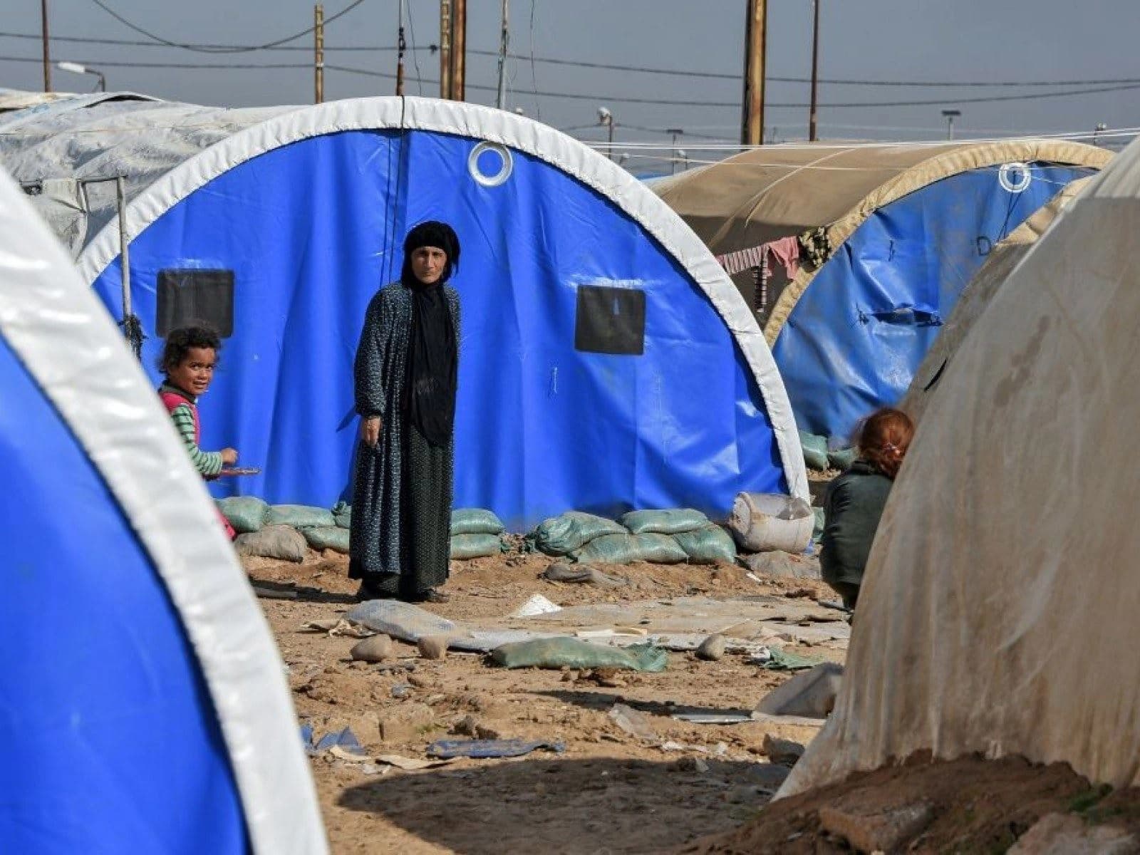 A woman and child are seen outside tents in al-Jad'a camp on the outskirts of Qayyarah, south of Mosul. AFP file photo
