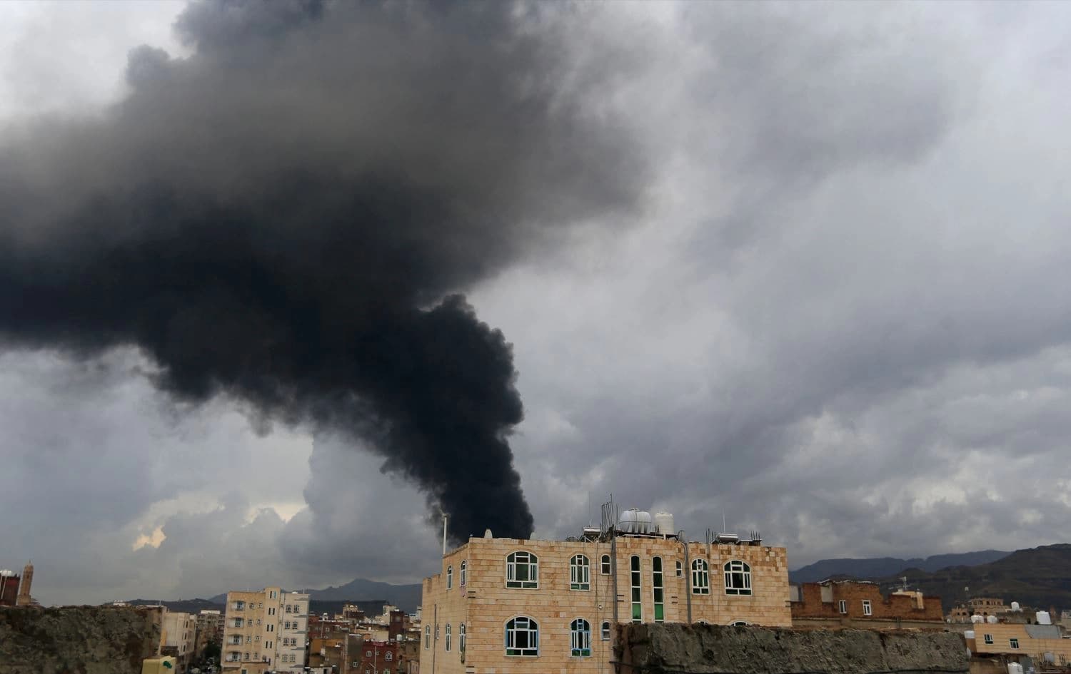 باڵەخانەیەک لە سەنعای پایتەختی یەمەن بۆردوومان کراوە و دووکەڵی رەشی لێ بەرزدەبێتەوە. وێنە: AFP