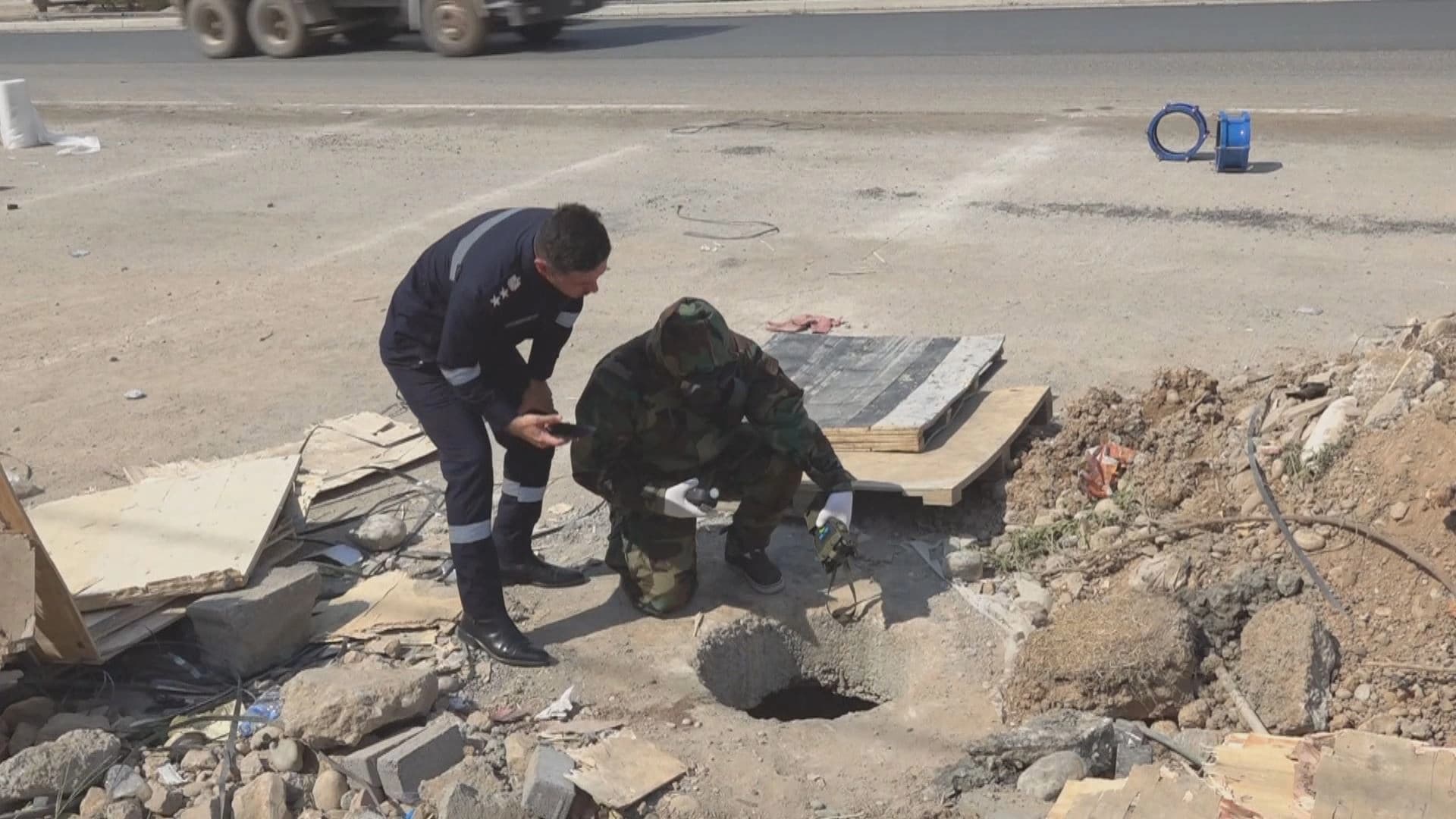 Security personnel and police inspect a Kirkuk sewer where two teenagers died while cleaning it. Photo: Screenshot/Rudaw