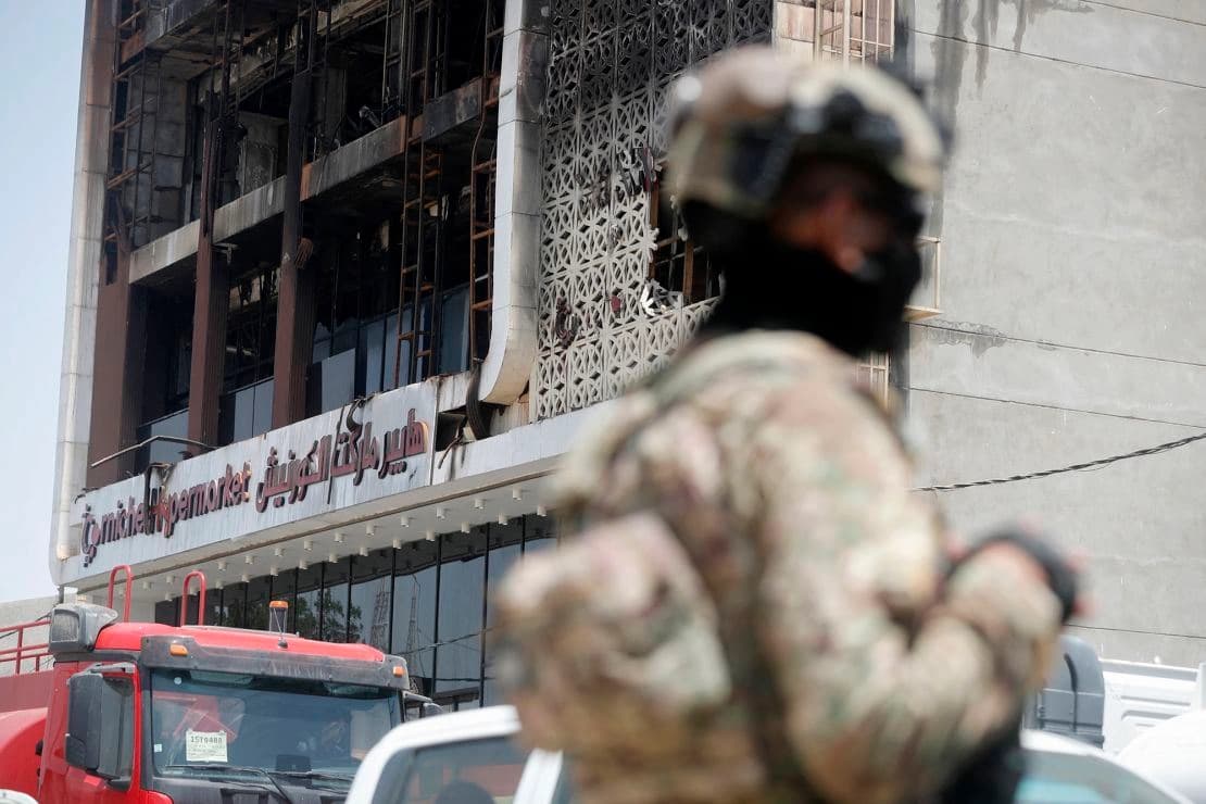 A member of the Iraqi security forces stands in front of a damaged shopping mall on July 16, 2025, after a fire tore through the newly opened building in the eastern Iraqi city of Kut overnight. Photo: AFP