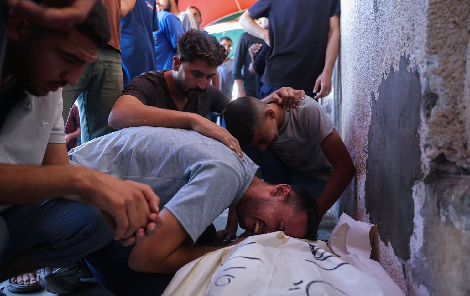 هاووڵاتییەکی غەززە لەسەر تەرمی ئازیزێکی بەکوڵ دەگریێت کە لەلایەن ئیسرائیلەوە کوژراوە. وێنە: AFP 