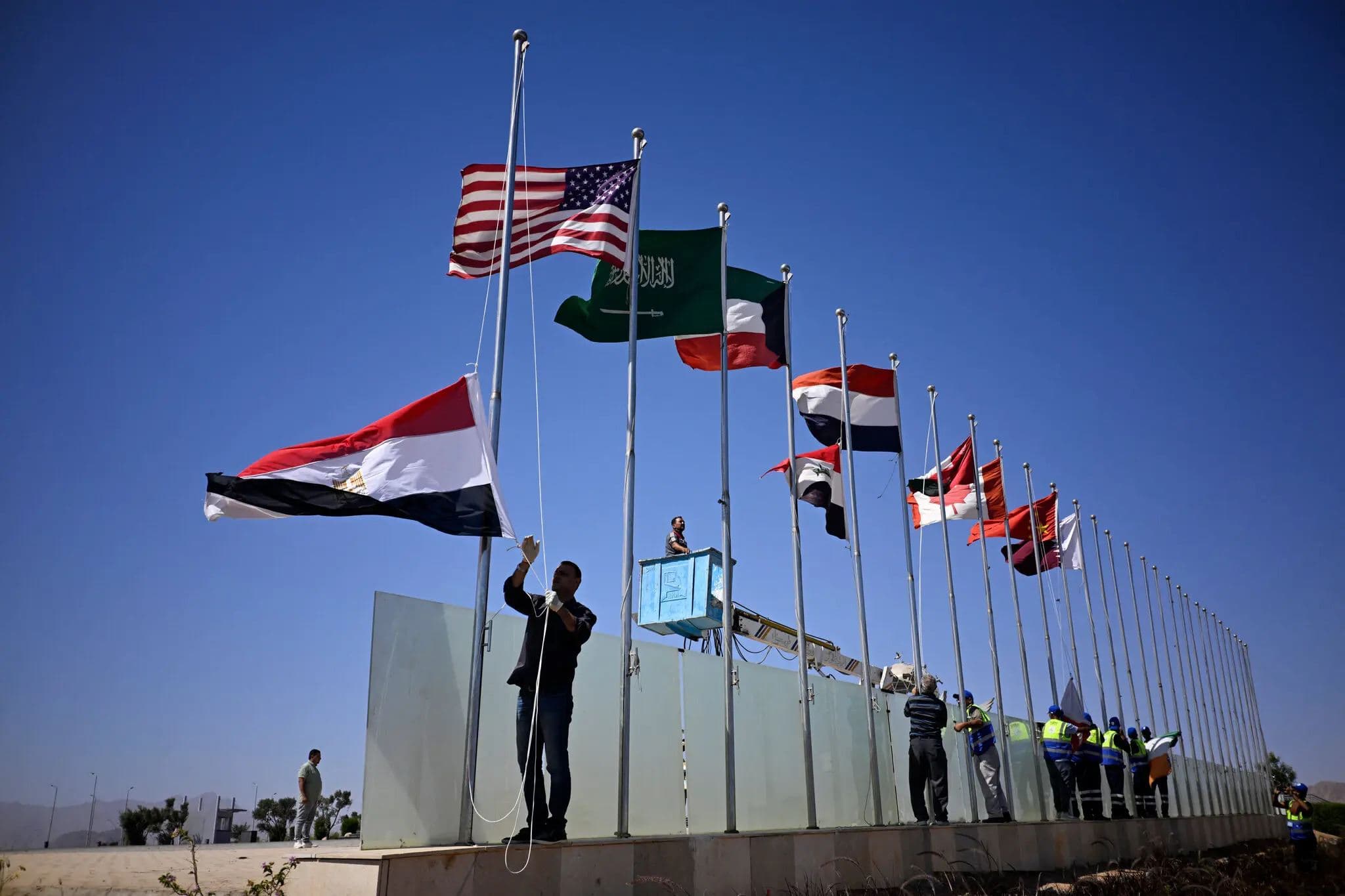Municipal employees raising flags in Sharm el-Sheikh, Egypt, on Saturday, October 11, 2025, before a summit about Gaza. Photo: AFP