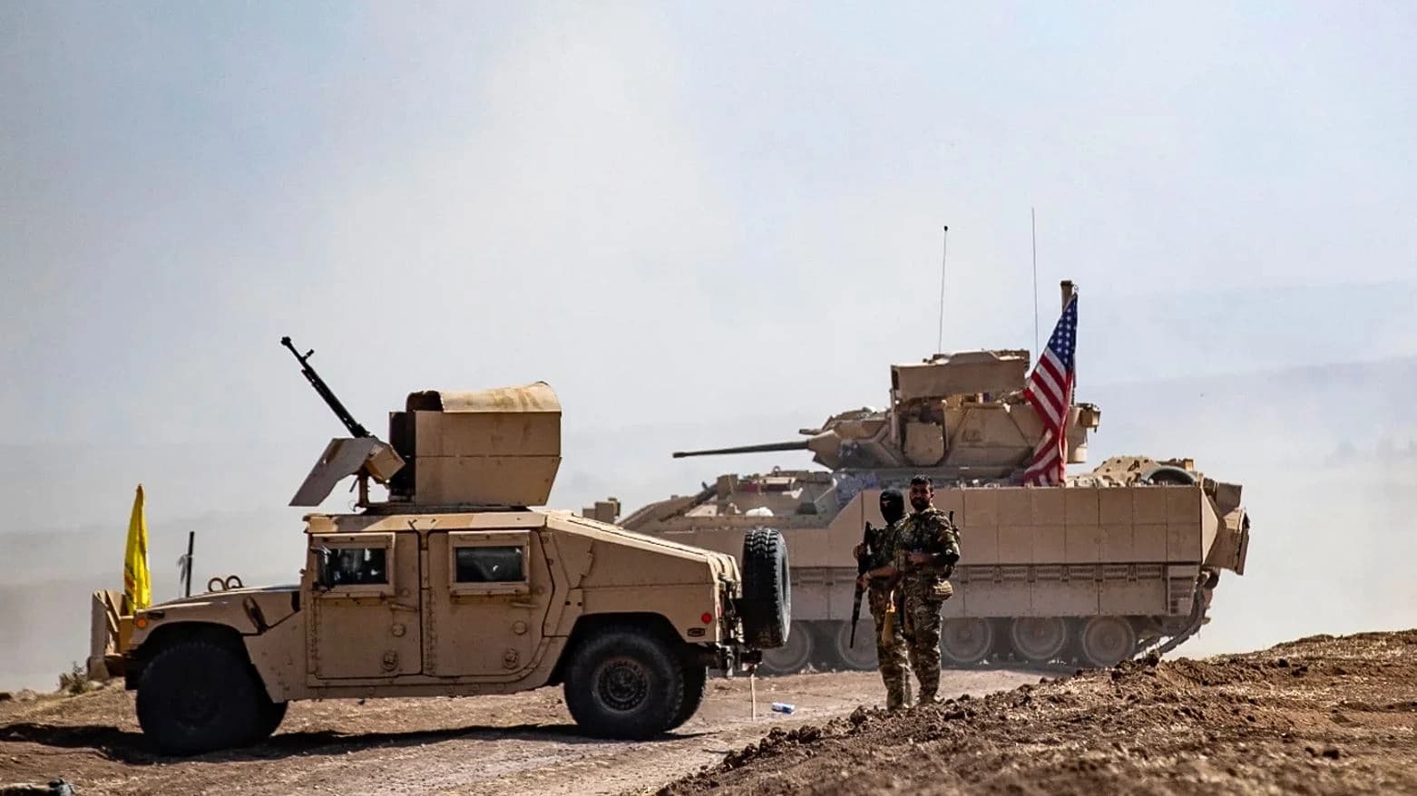 SDF fighters stand near a US armored vehicle during an anti-ISIS operation in al-Malikiya, Syria, in September 2022. AFP file photo