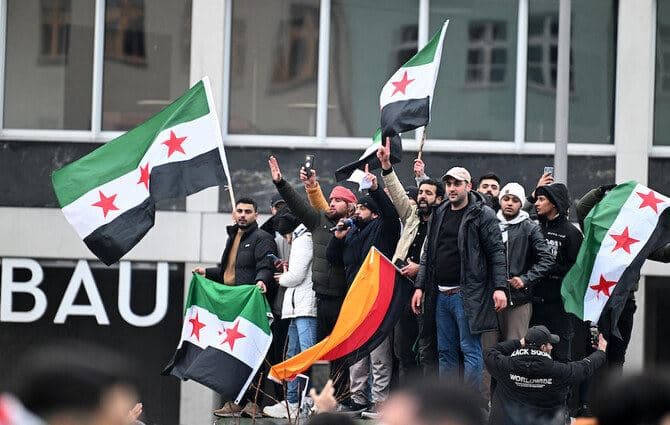Members of the Syrian community hold flags of Syria and Germany as they rally on Dec. 8, 2024 in Berlin, Germany, to celebrate the end of Bashar Assad’s rule. AFP file photo