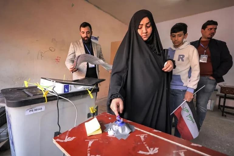 A woman dips her finger in ink after voting in Iraqi provincial council elections, in eastern Baghdad, in December 2023. AFP file photo