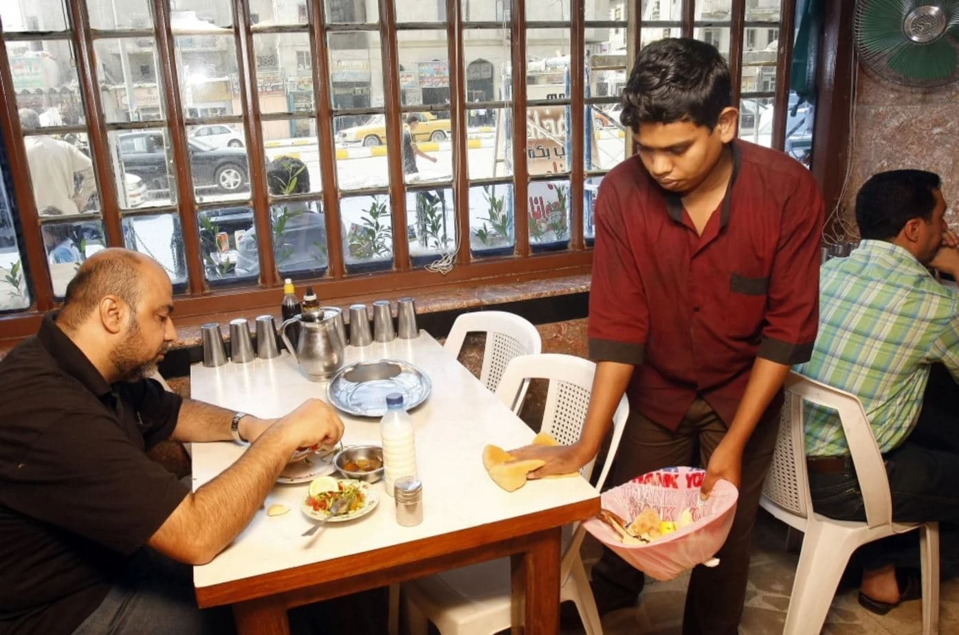 A Bangladeshi worker cleans a table at a restaurant in Baghdad. File photo: AFP