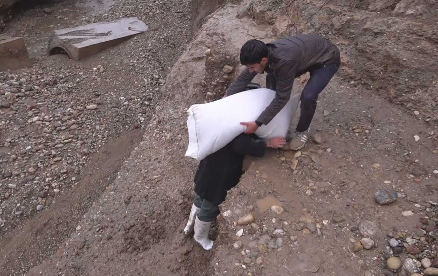 Residents of 10 villages north of Kirkuk province carry goods and basic necessities on their backs after a main bridge collapsed due to floods. Photo: Rudaw/screengrabs