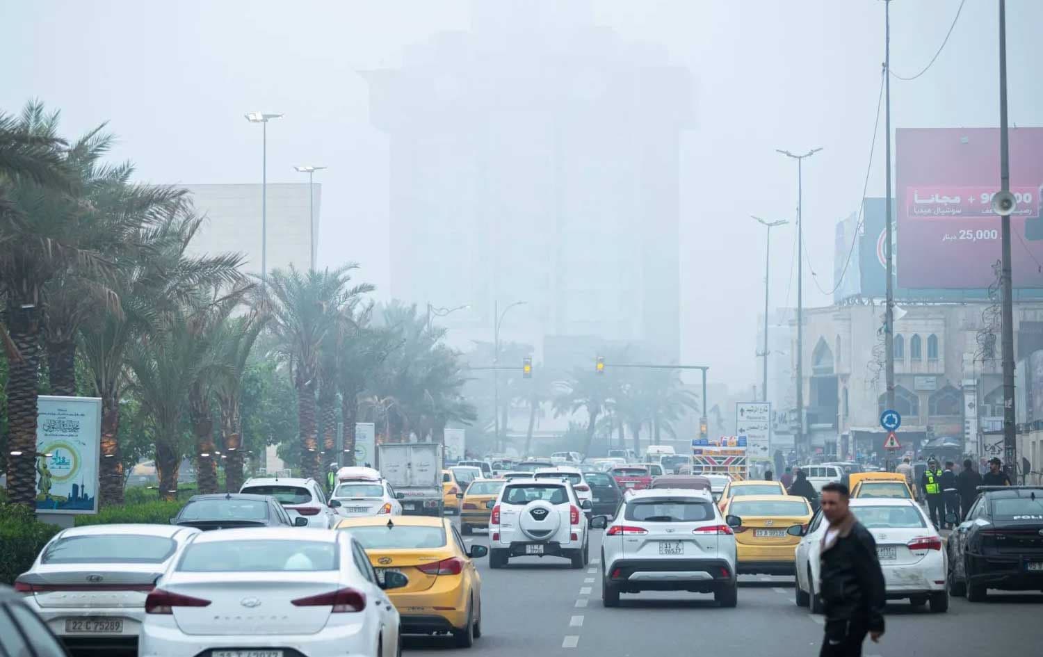 Cars drive through central Baghdad as fog blankets the city on December 11, 2025. Photo: AFP