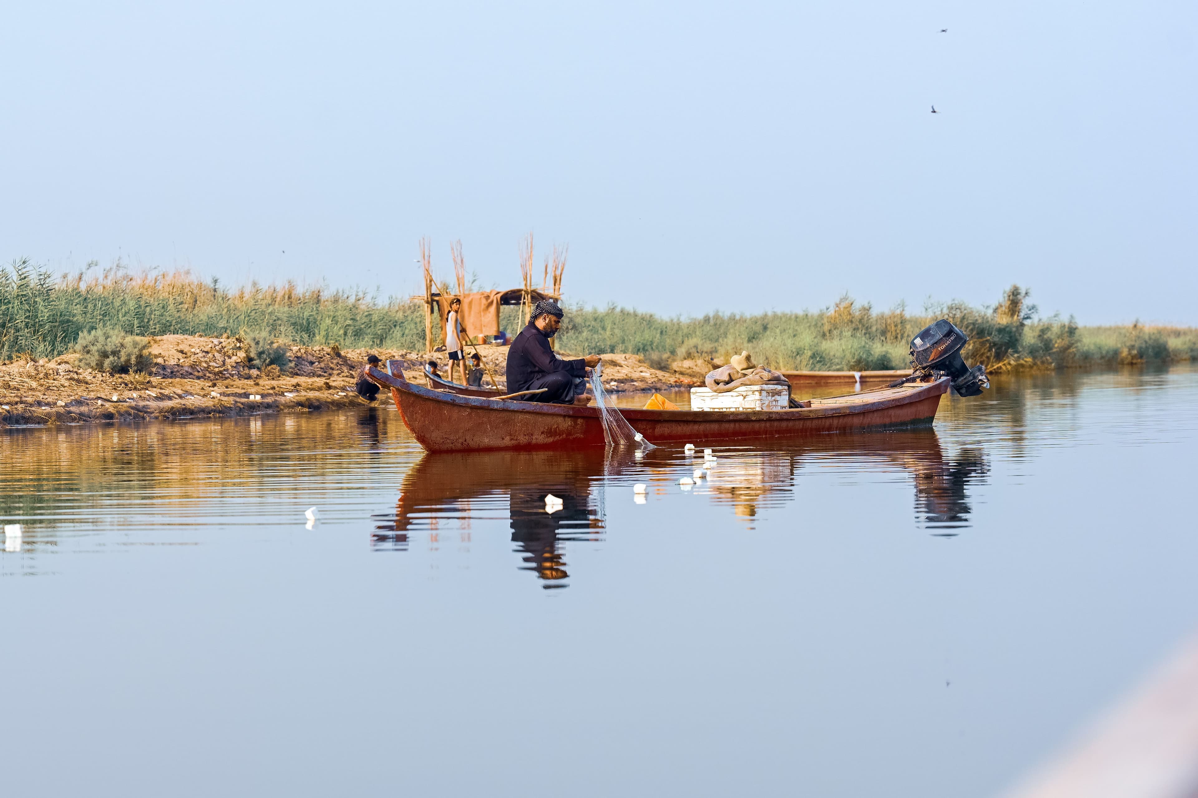 An Iraqi man in a boat as he goes out fishing early morning in marshland near Nasiriyah, Dhi Qar province, southern Iraq. Photo: Bilind T. Abdullah/Rudaw