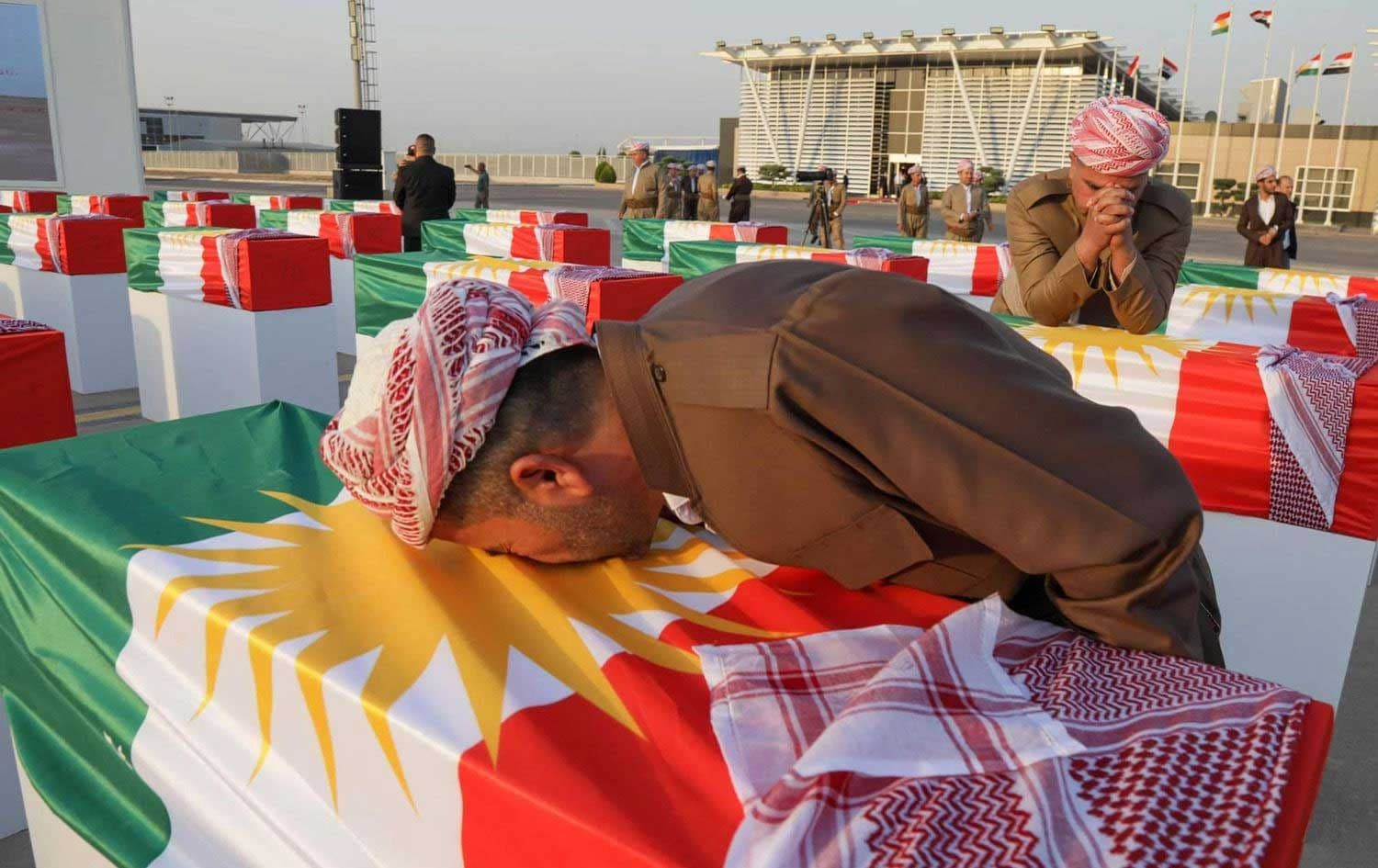 Barzani men mourn over coffins draped with the Kurdish flag and containing the remnants of victims of Barzan genocide on July 31, 2022. File photo: Bilind T. Abdullah/Rudaw
