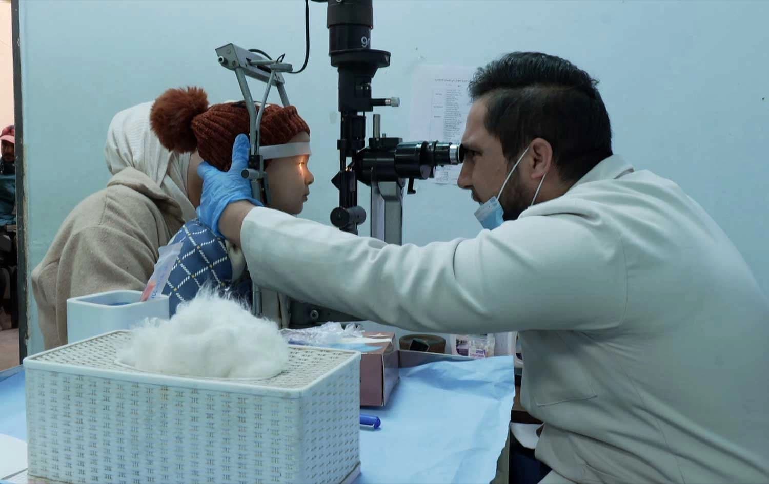 Dr. Hussein Karim, a specialist at Baghdad’s Ibn al-Haytham eye hospital, examines a child’s injured eye on January 1, 2026. Photo: screengrab/Rudaw